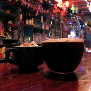 A coffee mug of tiramisu and a glass of Modern Time's 'Black House' coffee stout on the bartop at Golding's